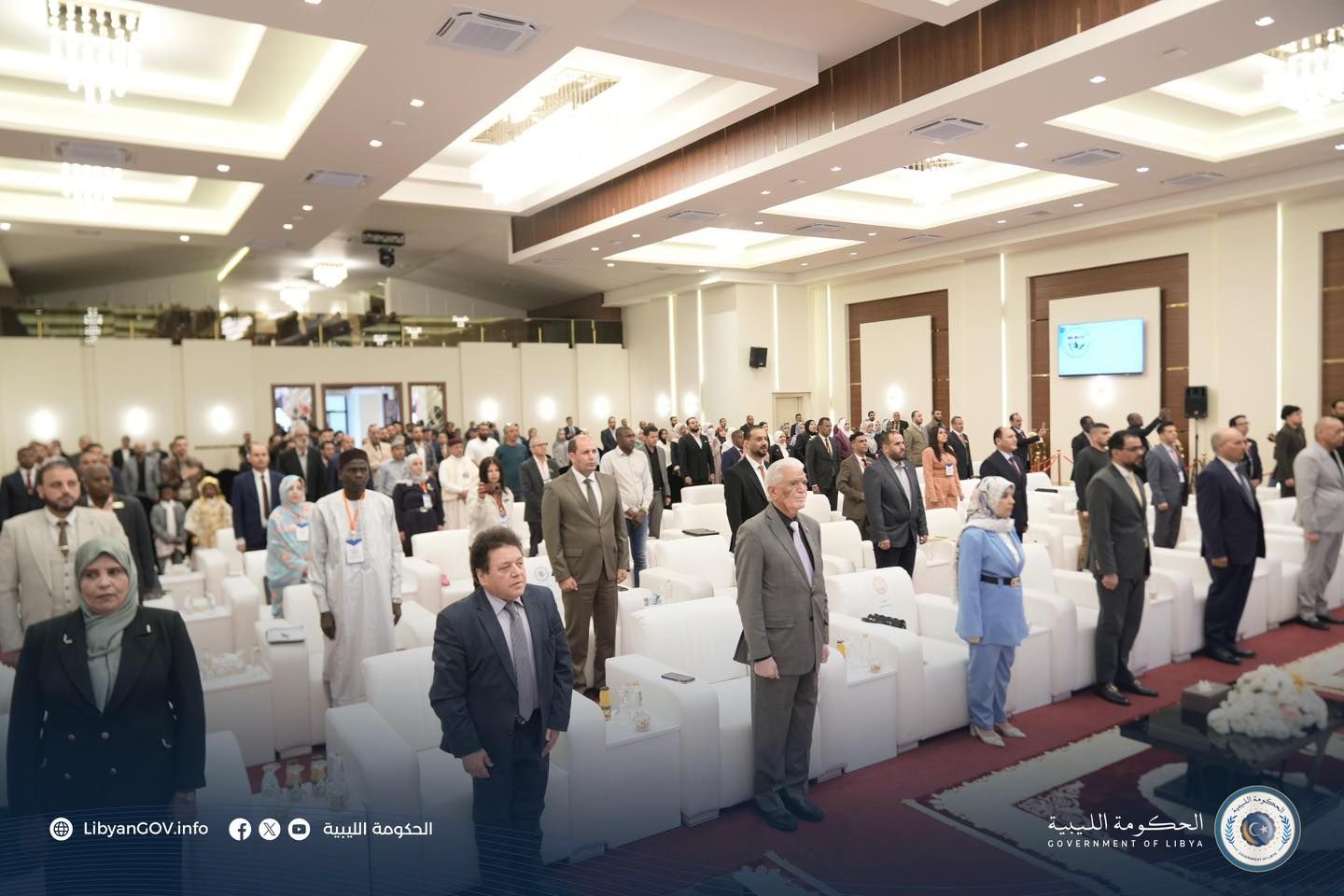 May be an image of ‎5 people, lighting, dais and ‎text that says '‎TIY Jlm عر LibyanGOV.info الليبية الحكومة الحكومةالبيية OFLIRYA LIBYA الليبية الحكومة GOVERNHER GOVERNHENTOFLIRYA 0‎'‎‎